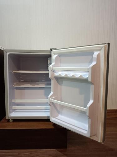 an empty refrigerator with its door open in a room at Baan Plaifah Khao Yai Hotel in Khao Yai