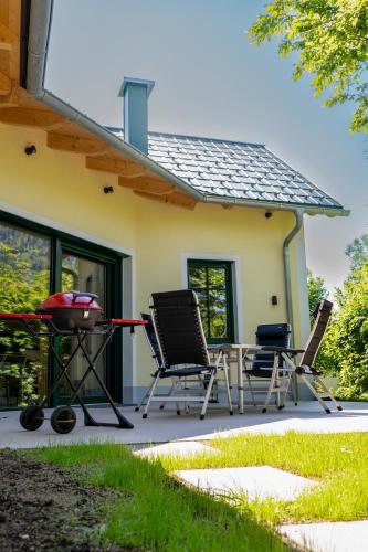 three chairs and a grill in front of a house at Cottage Bad Ischl in Bad Ischl