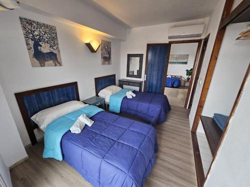 um quarto de hotel com duas camas e um repousa-pés em Le Mirage Ibiza em San Antonio
