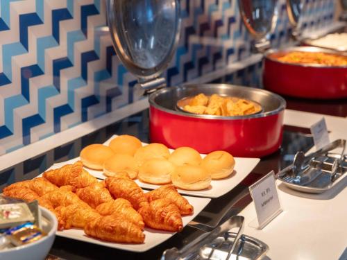 a buffet of food with pastries and croissants at Holiday Inn Express Shanghai Pudong Airport by IHG in Shanghai