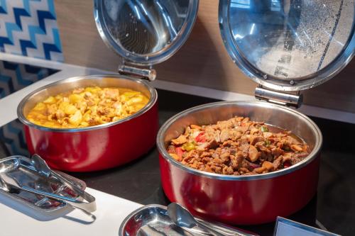 two pots of food sitting on a counter top at Holiday Inn Express Shanghai Pudong Airport by IHG in Shanghai