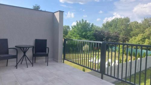 a patio with two chairs and a table on a balcony at Riverside Apartmanház Gyula in Gyula