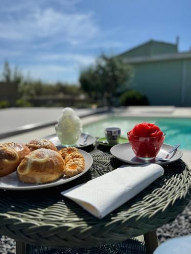 a table with plates of donuts and a bowl of ice cream at Sun Holidays Home in Marina di Modica