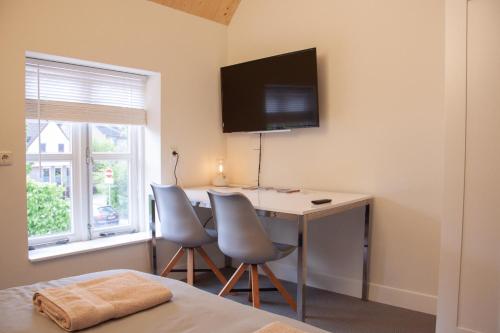 a room with a desk and two chairs and a table at B&B Wasboerderij Beek Ubbergen in Beek