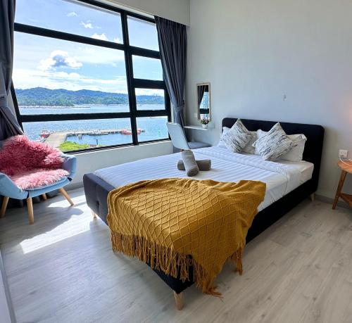 a bedroom with a bed and a large window at JQ1 SEA & POOL or CITY View WIFI I WASHING MACHINE for Some Units I CUCKOO WATER Jesselton Quay by R2 in Kota Kinabalu