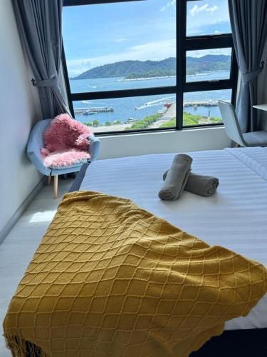 a bedroom with a bed and a large window at JQ1 SEA & POOL or CITY View WIFI I WASHING MACHINE for Some Units I CUCKOO WATER Jesselton Quay by R2 in Kota Kinabalu