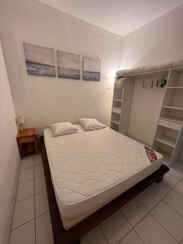 - une chambre avec un lit et des étagères dans l'établissement Appartement port GRUISSAN, à Gruissan