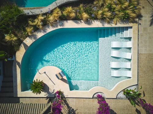an overhead view of a swimming pool with palm trees at La Moraleja The Quiet Hotel - Adults Only in Cala de Sant Vicenc