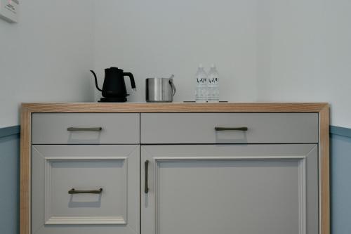 a white cabinet with a wooden counter top at Lequ Okinawa Chatan Spa ＆ Resort in Chatan