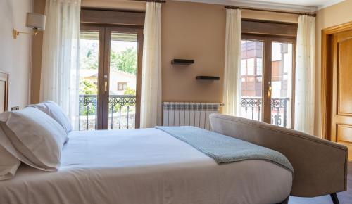 ヌエバ・デ・リャネスにあるApartamentos San Jorgeのベッドルーム1室(ベッド1台付)、バルコニー(窓付)