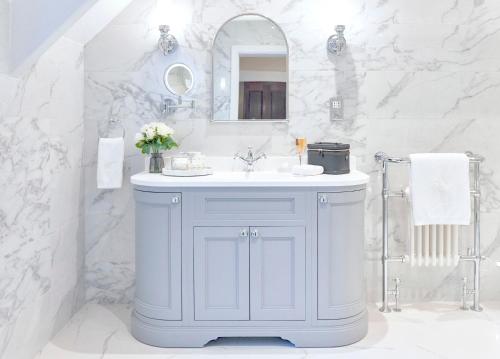 uma casa de banho branca com um lavatório e um espelho em Matfen Hall Hotel, Golf & Spa em Matfen