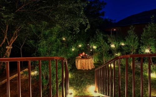 a night view of a garden with a table with lights at The Earth at Ranthambore in Sawāi Mādhopur