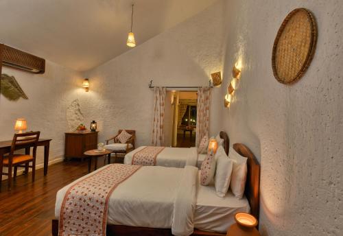 a hotel room with two beds and a dining room at The Earth at Ranthambore in Sawāi Mādhopur