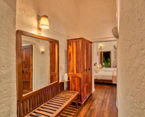 a room with a wooden cabinet and a bedroom at The Earth at Ranthambore in Sawāi Mādhopur