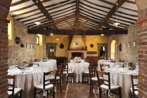 a room with white tables and chairs in a building at Hotel Borgo Casabianca in Serre di Rapolano
