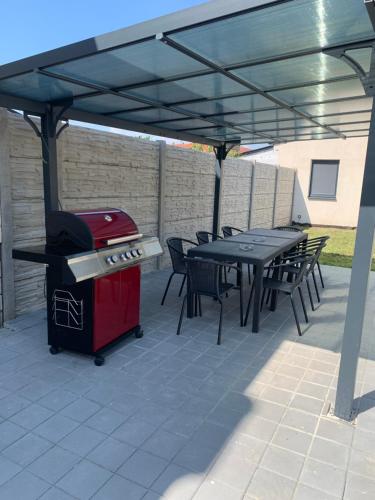 a patio with a grill and tables and chairs at Penzion Pálava in Nové Mlýny