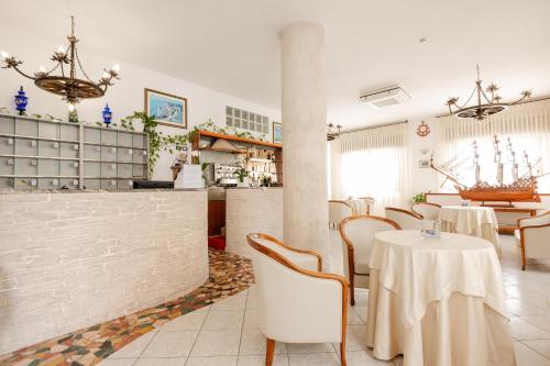 a restaurant with tables and chairs in a room at Hotel La Caravella in Vieste