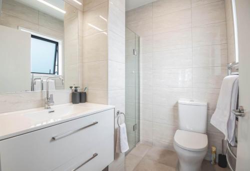 a bathroom with a toilet and a sink and a shower at ACL Studio Units in Auckland