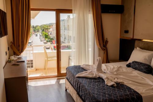 a bedroom with a bed and a large window at Vois Kemer Hotel in Kemer