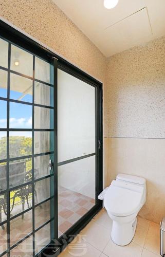 a bathroom with a toilet and a sliding glass door at 清境 百里莊園 Baili Manor Cing Jing in Renai