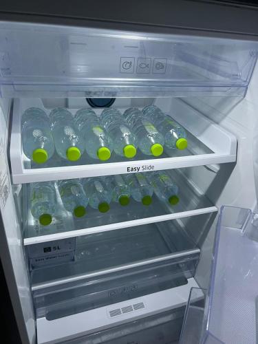 an empty refrigerator with water bottles and balls in it at Pani House Hatyai 4 in Hat Yai