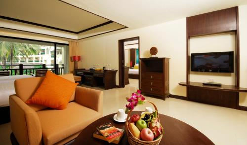 sala de estar con sofá y mesa con un bol de fruta en Khaolak Orchid Beach Resort - SHA Extra Plus, en Khao Lak