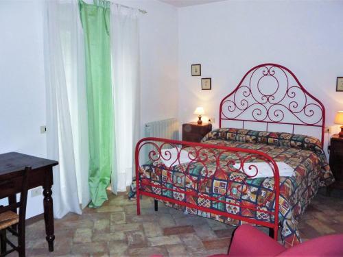 um quarto com uma cama vermelha e uma cortina verde em Belvilla by OYO Colombaia em Mantignana