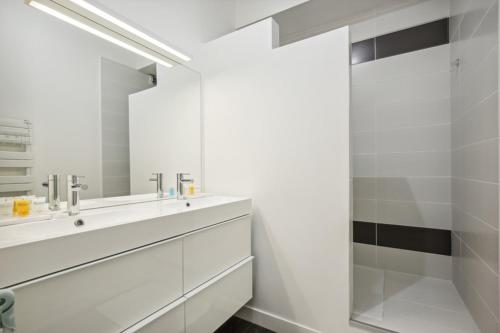 une salle de bain blanche avec un lavabo et une douche dans l'établissement 607 Suite Paradis - Superb apartment in Paris, à Paris