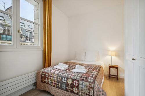 une petite chambre avec un lit et une fenêtre dans l'établissement 607 Suite Paradis - Superb apartment in Paris, à Paris