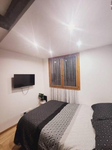 une chambre avec un lit et une télévision à écran plat dans l'établissement Coqueto Estudio, à Paris