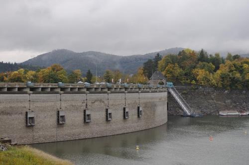 a dam on a river with a bridge in the background at Haus Blick am Edersee in Waldeck