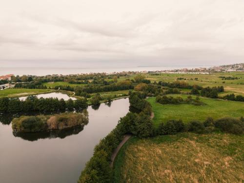 an aerial view of a river with trees and grass at ibis Styles Deauville Villers Plage in Villers-sur-Mer