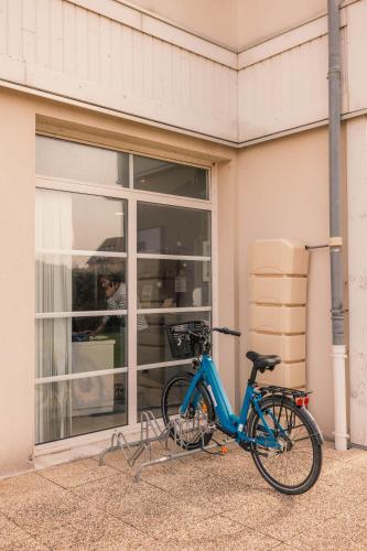a blue bike parked in front of a building at ibis Styles Deauville Villers Plage in Villers-sur-Mer