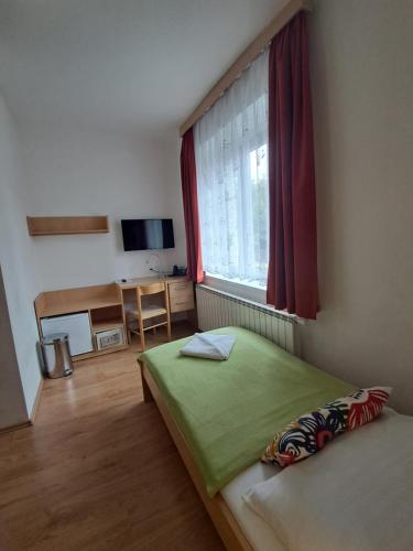 - une chambre avec un lit vert et une fenêtre dans l'établissement Hotel Garni Rambousek, à Prague