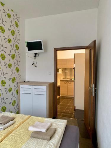 a room with two beds and a television on the wall at Penzion Pálava in Nové Mlýny