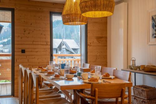 une longue salle à manger avec une longue table et des chaises dans l'établissement Cairn Harmony - Apartment B209, aux Gets