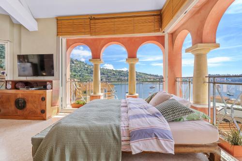 une chambre avec un lit et un balcon dans l'établissement Penthouse La Bellevue, à Villefranche-sur-Mer