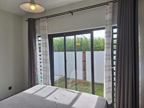 a bedroom with a bed and a large window at BM Residence in Grand-Baie