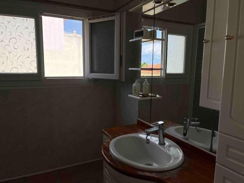une salle de bain avec un lavabo et deux fenêtres dans l'établissement Antibes/Juan les pins, cosy apartment, à Antibes