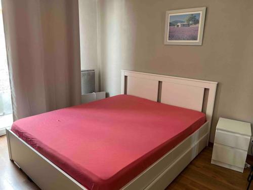 une chambre avec un lit avec une couverture rouge dans l'établissement Antibes/Juan les pins, cosy apartment, à Antibes