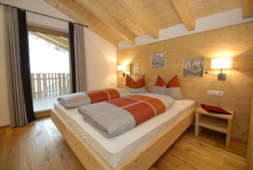 um quarto com uma cama grande e uma janela grande em Mühlerhof em Funes