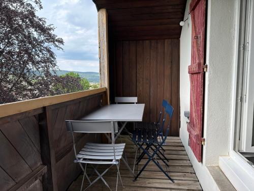 - une table et des chaises sur la terrasse couverte d'une maison dans l'établissement Gérardmer chalet le Belvédere vue lac, piste de ski, à Gérardmer