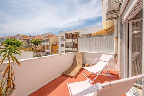 een balkon met stoelen en uitzicht op de gebouwen bij GuestReady - Relaxing stay in Cacilhas in Almada