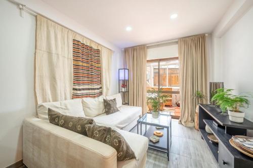 een woonkamer met een witte bank en een raam bij GuestReady - Relaxing stay in Cacilhas in Almada