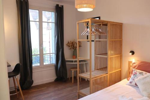 - une chambre avec un lit, une étagère et un bureau dans l'établissement Chez Guillaume joli Studio, RER proche château et direct Paris, Petite Cour ensoleillée, à Versailles