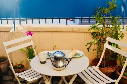 - une table avec une bouilloire et 2 chaises dans l'établissement Chez Guillaume joli Studio, RER proche château et direct Paris, Petite Cour ensoleillée, à Versailles