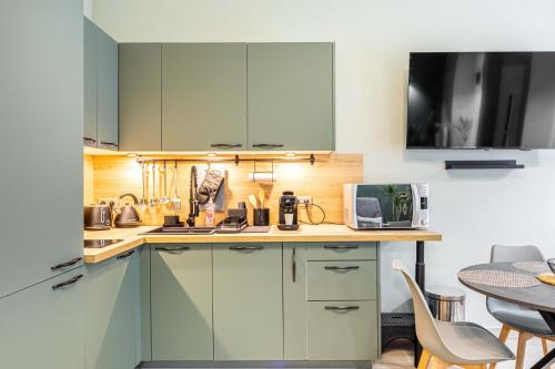 une cuisine avec des placards verts et une table dans l'établissement Taste of Paris near Montmartre Sacre Coeur, à Paris