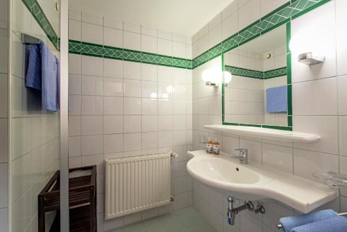 a white bathroom with a sink and a mirror at Hotel 3 Mohren in Oetz