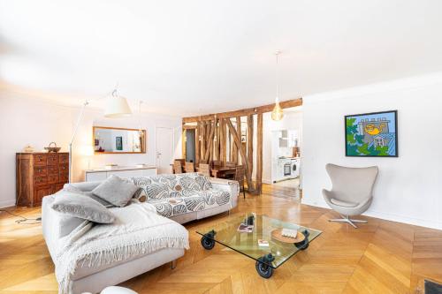 un salon avec un canapé et une table en verre dans l'établissement GuestReady - Apt. Lumineux pour 2 près du Marais, à Paris