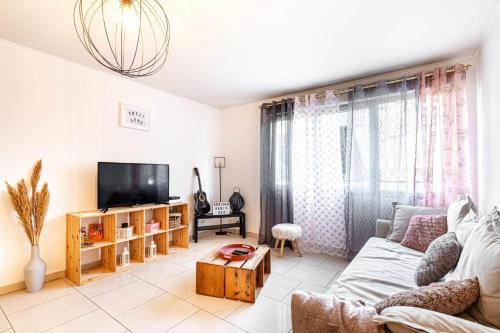 - un salon avec un canapé et une télévision dans l'établissement GuestReady - Bright and charming stay near Paris, à Saint-Denis